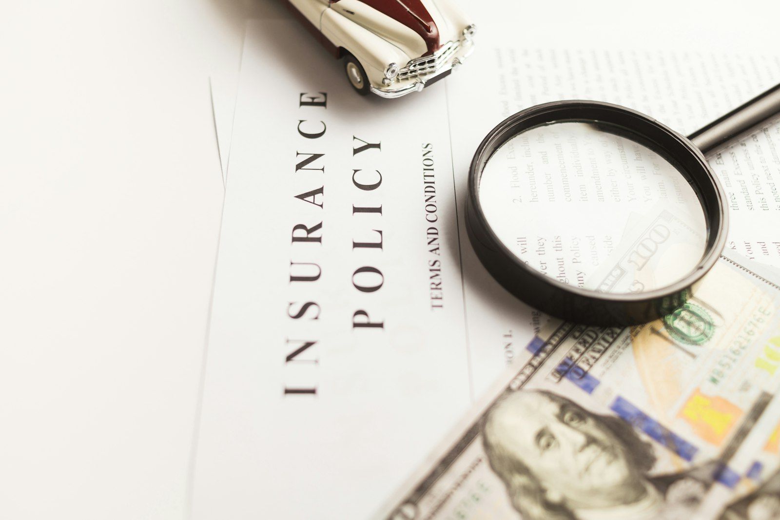 Magnifying glass resting on an insurance policy document.