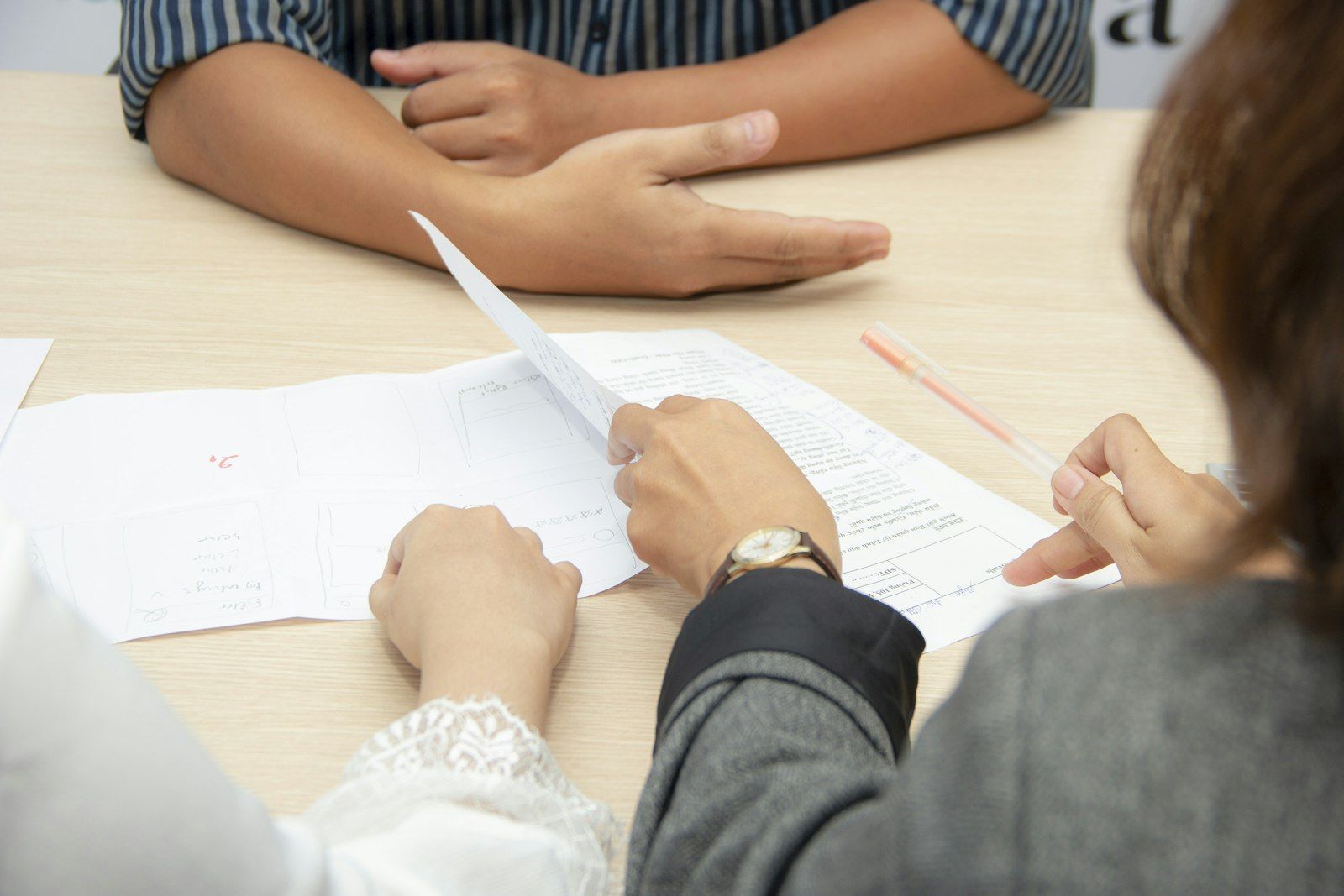 Two people reviewing documents at a meeting table.
